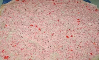 Put a third lavash, press lightly, distribute the filling of crab sticks.