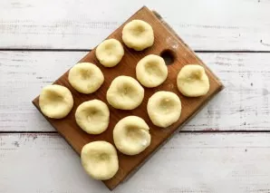 Divide the dough into several parts. Take one part, knead into a circle and make a recess in the middle.