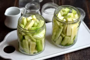 Put the cubes of cucumbers and zucchini tightly in jars. If the strips are placed vertically, then more will fit.