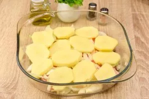 Cut the peeled potatoes into slices and put half of the potatoes on top of the onion.