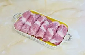 Grease the baking dish with vegetable oil and put meat rolls in it. So that the meat does not dry out during frying, grease the tops of t...