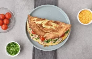 Fold the omelette in half so that the filling is slightly visible and place it on a plate. Repeat everything to cook the second omelette.