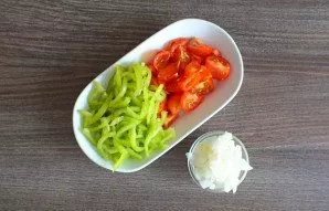 Cut the tomatoes into quarters. Pepper in thin strips. Onions in small pieces.