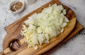 Meanwhile, peel the onion and cut into medium-sized pieces. Finely chop the garlic.