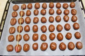 Remove the dough from the refrigerator. Line the baking sheet with baking paper. Take a small piece of dough and knead into cherry-sized ...