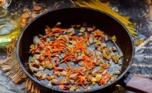 Fry carrots, onions and bacon for a few minutes in a pan. Put in a saucepan.