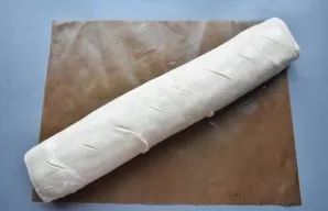 Using the silicone mat on which you rolled the dough, roll it up. Fix the edges of the roll and place the seam down. Wrap the roll very c...