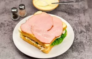 Cover everything with a second toast and put ham on it.