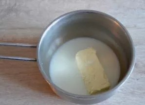 Pour 50 grams of butter into a saucepan and pour 50 grams of milk, heat.