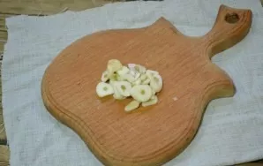 Cut a few cloves of garlic into thin plates, send to a multicooker bowl along with tomato juice, salt, pepper and spices.