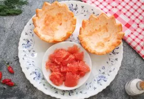 Cut the grapefruit into two halves. With a sharp knife, swipe along the peel and remove the pulp with a spoon without damaging the peel. ...