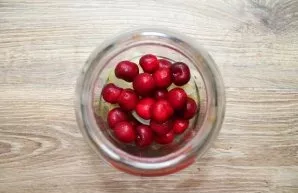 Remove the stems from the cherries and place them in the jar with the pears.