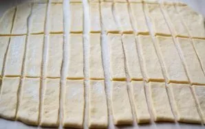 Sprinkle the work surface with flour and roll out the dough into a layer about 1-2 mm thick. Cut the dough into strips 2-3 cm wide. Then ...