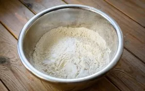 Put all the wheat flour in a bowl, add soda and stir these ingredients with a spoon to distribute evenly.