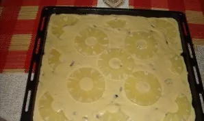 Pour the batter onto the baking sheet and arrange the pineapple slices.