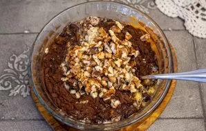 Mix the swollen flakes and the egg-banana mixture, add chopped walnuts and mix the dough well.