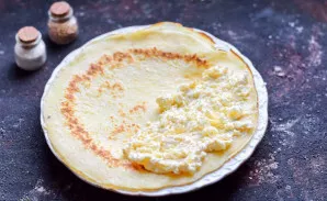 Put part of the prepared filling on the edge of the pancake.