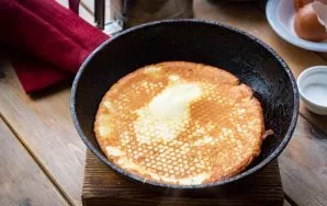 Heat the pan, grease it with a thin layer of vegetable oil, lay out a portion of dough and distribute it evenly over the pan. Fry the pan...