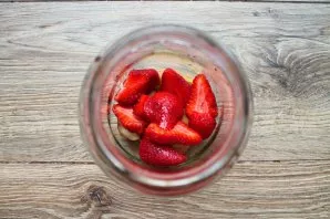 Remove the stems from the strawberries and put the berries in a jar with pears.