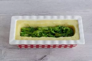 Then put the broccoli in the well. Press with a spoon.