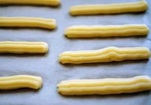 Line the baking sheet with baking paper and squeeze out small pieces of dough. Strips of dough can be curly and even horseshoe-shaped, as...
