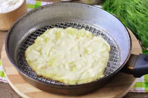 Heat a little oil in a pan, put a couple of tablespoons of zucchini dough and smooth it out, start baking cakes over medium heat.