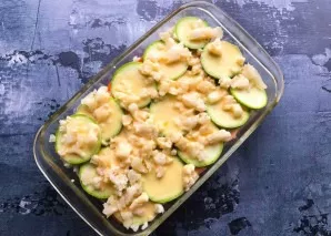 Finely chop the cauliflower and put it on top of all the vegetables. Mix eggs with sour cream, beat well and pour over vegetables. Send t...