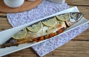 In the oven, baked mackerel with carrots is ready, serve decorated with lemon slices and a sprig of parsley. Delicious.