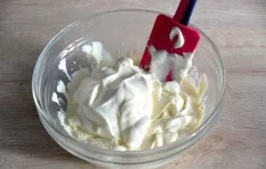 Pour sour cream into the curd mass, mix.