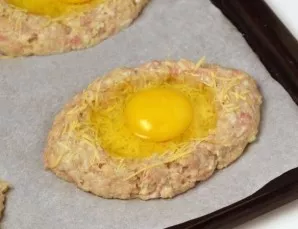 In the center of each schnitzel, gently beat an egg. Place back in the oven and bake for another 20 minutes.