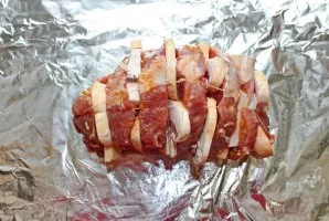 Tie the accordion with a kitchen cord so that it does not disintegrate. Put the meat on top of the foil and wrap it tightly.