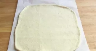 Divide the dough into 2 unequal parts. Place most of it on baking paper and roll it into an oval shape. Roll out the smaller portion of t...