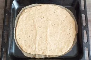 After the time has passed, remove the dough from the refrigerator. Roll out into a 3 mm thick layer, place on baking paper, then on a bak...