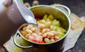 Pour water into the pot, add salt and pepper.