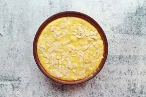 Pour the remaining dough over the jam and level it. Sprinkle chopped nuts or almond petals on top of the cake.