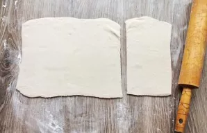 Roll out the dough a little and cut it into two parts, 2/3 and 1/3 of the layer.