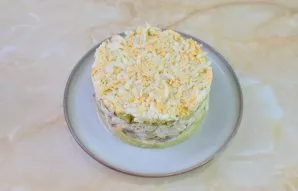 Add boiled eggs to the last layer. They can be finely chopped or grated. Remove the serving ring from the salad.