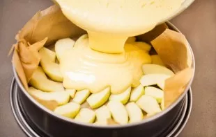 Pour the dough over the apples.
