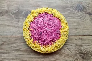 Grate the eggs on a medium grater and decorate the top of the salad to taste. Put in the refrigerator and let stand for 30-45 minutes.