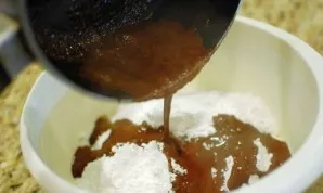 Put icing sugar in a bowl, pour the prepared hot mixture, add vanilla and chopped nuts, mix.