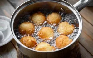 Then heat all the vegetable oil in a saucepan over medium heat. From the whole mass of dough separate small pieces weighing about 30 gram...