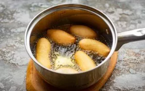 In a saucepan over medium heat, heat a large amount of vegetable oil. Cut off the tip of a pastry bag with dough and carefully squeeze th...