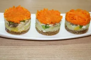 Put the form on a breadbasket and lay out in layers, lightly coating with mayonnaise, potatoes, onion letters, mackerel and carrots.