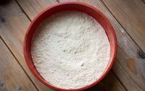 Add half the flour crumbs to the baking dish and distribute them in an even layer with a spoon.