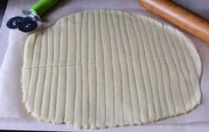 With a sharp knife, cut the dough into narrow strips about 5 mm wide.