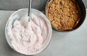 Pour the prepared raspberry jelly on one side, first mix it with a small amount of cottage cheese. Stir in half of the whipped cream.