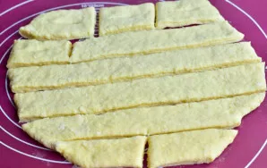 Roll out the dough and cut it into strips, and then into pieces.