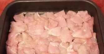 Grease a baking sheet with oil and lay out the chopped chicken fillet along its entire perimeter.