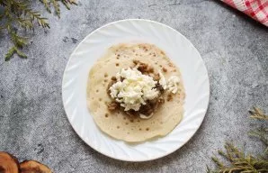 Transfer the pancake from the pan to a plate, fried side down. In the center put a tablespoon of fried minced meat with leeks and grated ...