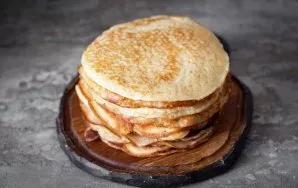 Baked pancakes are plump with holes and look very appetizing.